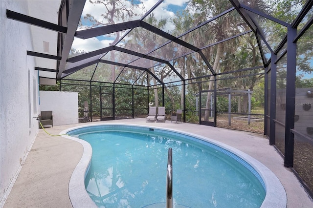 pool featuring a patio area and glass enclosure