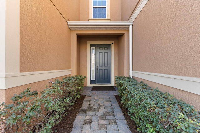 property entrance with stucco siding