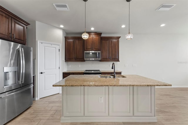 kitchen with a sink, stainless steel appliances, tasteful backsplash, and visible vents