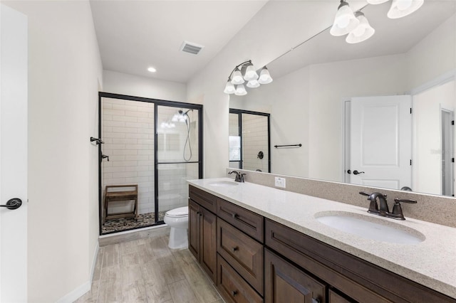 bathroom with toilet, a sink, and a stall shower
