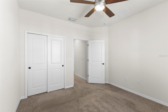 unfurnished bedroom featuring a closet, carpet floors, visible vents, and baseboards