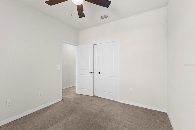 unfurnished bedroom featuring carpet flooring, baseboards, ceiling fan, visible vents, and a closet