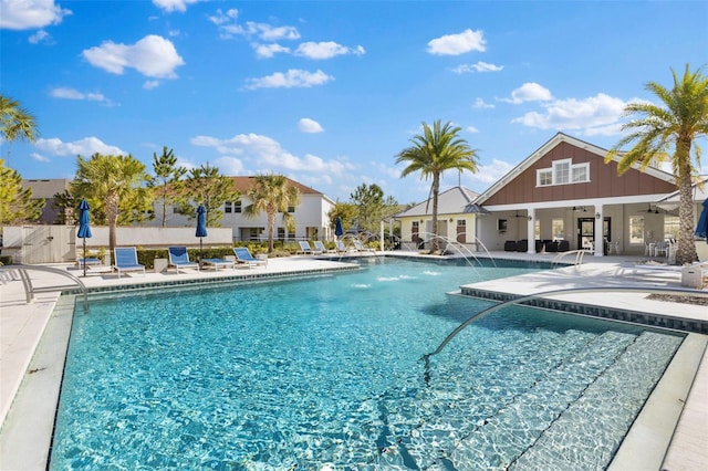 pool with ceiling fan, fence, and a patio