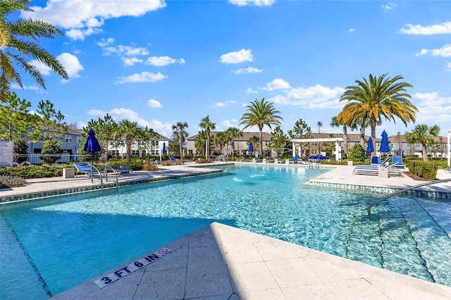 pool with a patio and fence