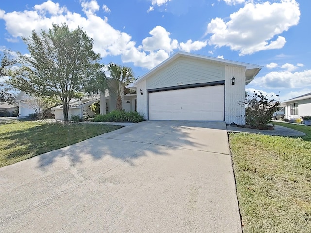 view of front of home with a front lawn, driveway, and a garage