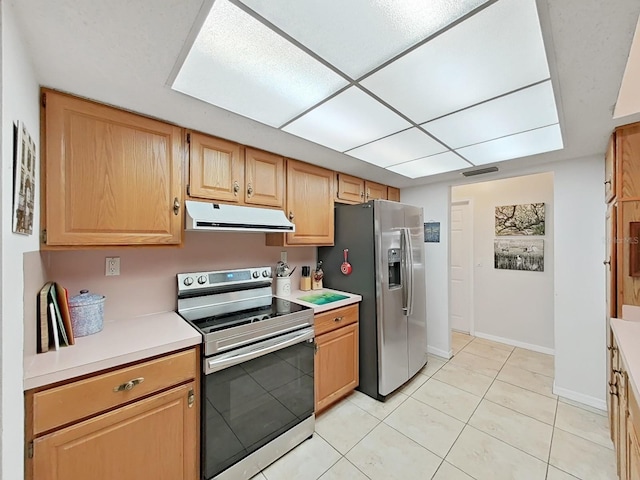 kitchen featuring light countertops, appliances with stainless steel finishes, under cabinet range hood, baseboards, and visible vents