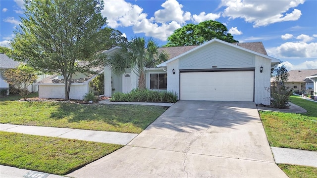 ranch-style house featuring driveway, a garage, and a front lawn