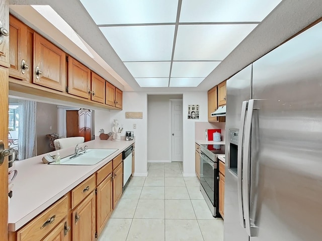 kitchen with light tile patterned flooring, light countertops, a sink, under cabinet range hood, and stainless steel appliances