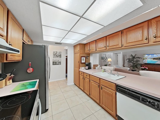 kitchen with light countertops, a sink, light tile patterned floors, and dishwasher
