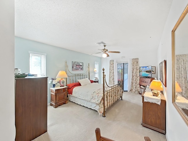 bedroom with light colored carpet, access to outside, a textured ceiling, ceiling fan, and visible vents