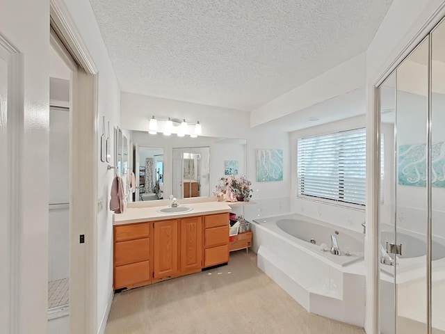 bathroom with a shower stall, a textured ceiling, vanity, and a garden tub
