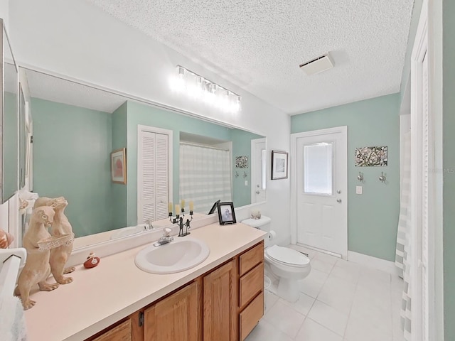 bathroom with vanity, toilet, a textured ceiling, tile patterned floors, and visible vents