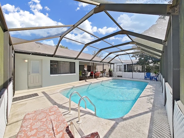 pool with glass enclosure and a patio area