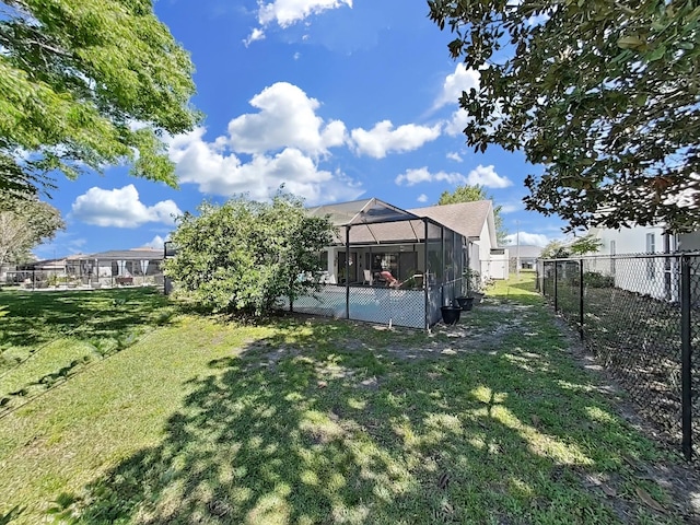 view of yard featuring fence and a lanai