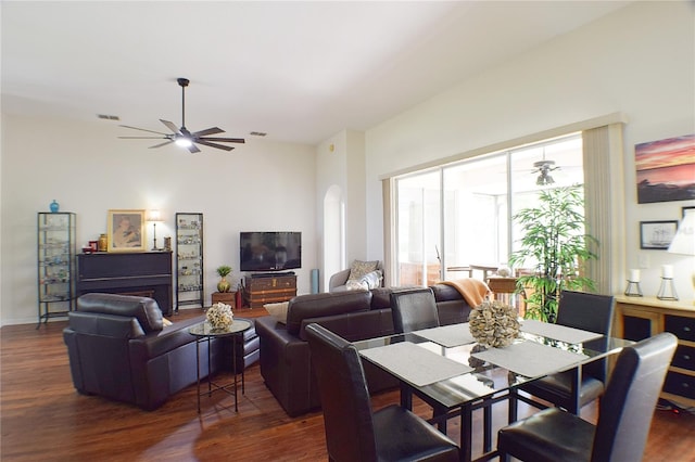 dining area with visible vents, arched walkways, dark wood-style floors, and ceiling fan