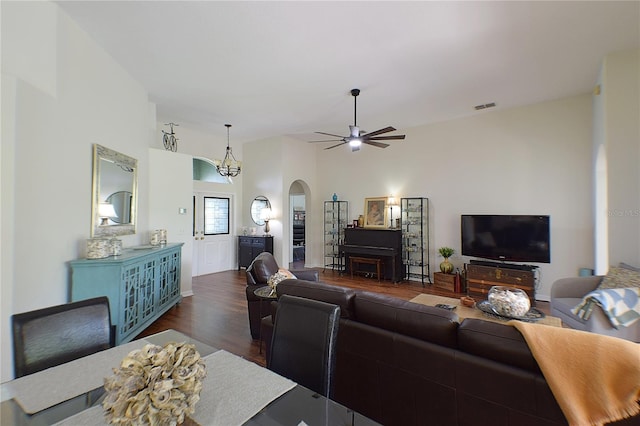 living room featuring dark wood-style floors, visible vents, arched walkways, and a ceiling fan