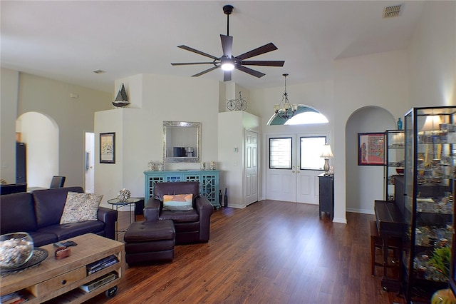 living area with visible vents, baseboards, ceiling fan, arched walkways, and dark wood-style floors
