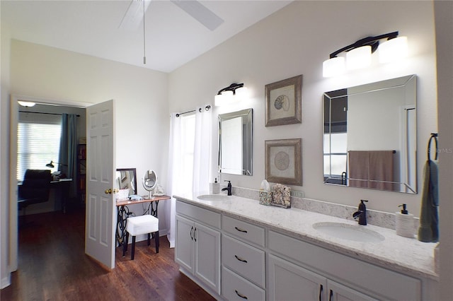 full bath with double vanity, wood finished floors, ceiling fan, and a sink