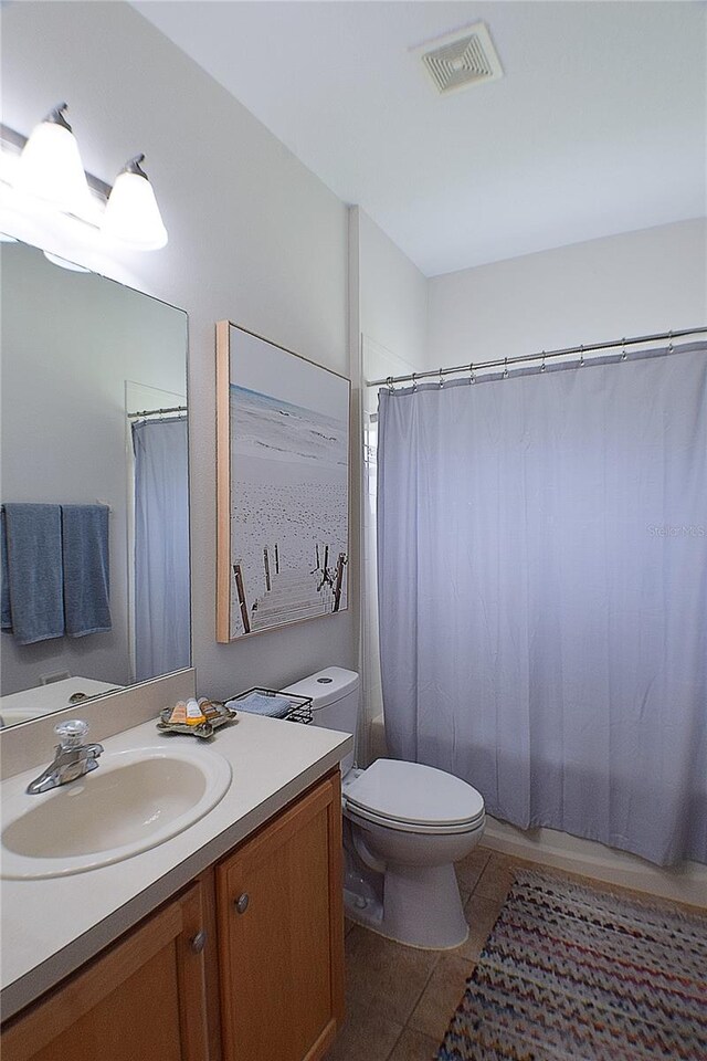 bathroom with visible vents, toilet, tile patterned flooring, and vanity