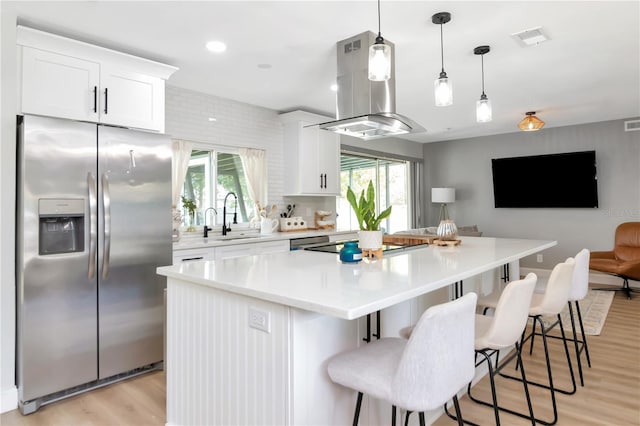 125 Siobhan Ave, Tampa, FL 33613 - kitchen featuring stainless steel refrigerator with ice dispenser, island range hood, a kitchen island, visible vents, and light wood-style flooring