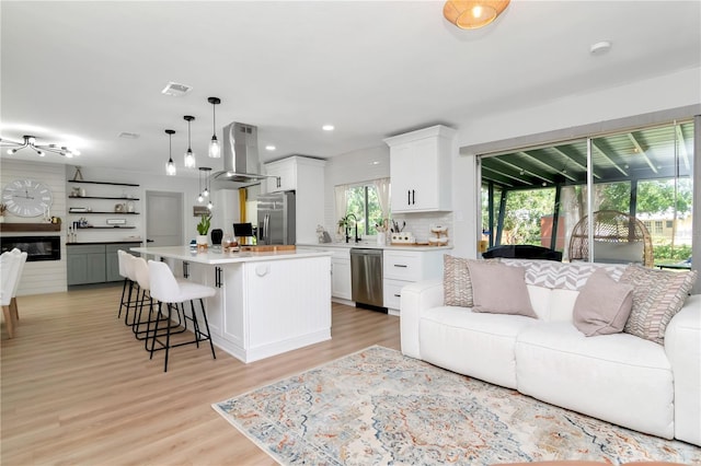 125 Siobhan Ave, Tampa, FL 33613 - kitchen with island exhaust hood, open floor plan, a breakfast bar area, and appliances with stainless steel finishes