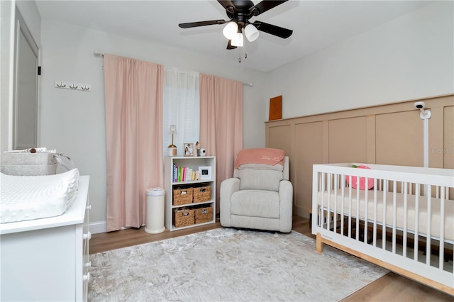 125 Siobhan Ave, Tampa, FL 33613 - bedroom with wood finished floors, a crib, and ceiling fan