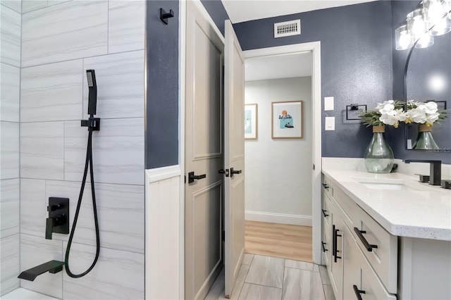 125 Siobhan Ave, Tampa, FL 33613 - bathroom featuring baseboards, visible vents, a shower, and vanity