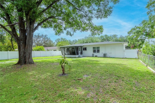125 Siobhan Ave, Tampa, FL 33613 - rear view of house featuring a fenced backyard, a lawn, a sunroom, and central AC