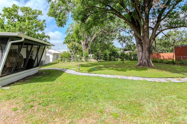 125 Siobhan Ave, Tampa, FL 33613 - view of yard with a fenced backyard, a sunroom, and central air condition unit