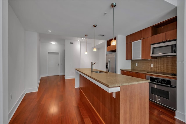kitchen featuring a sink, tasteful backsplash, modern cabinets, brown cabinetry, and stainless steel appliances