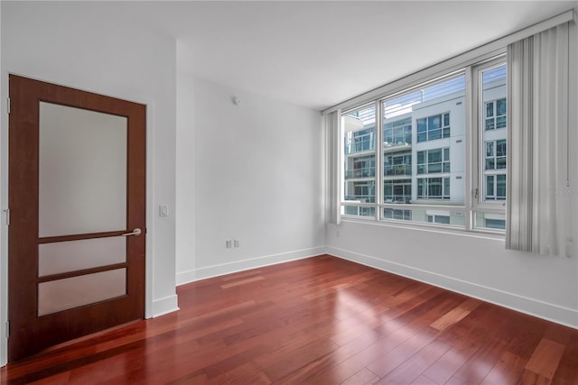 empty room featuring baseboards and wood finished floors