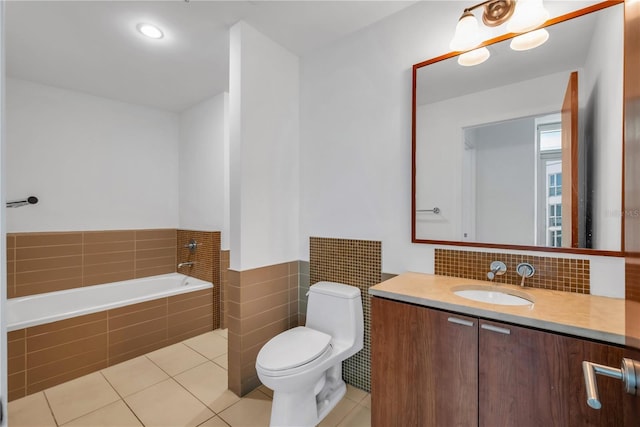 full bathroom with tiled bath, tile patterned floors, vanity, and toilet