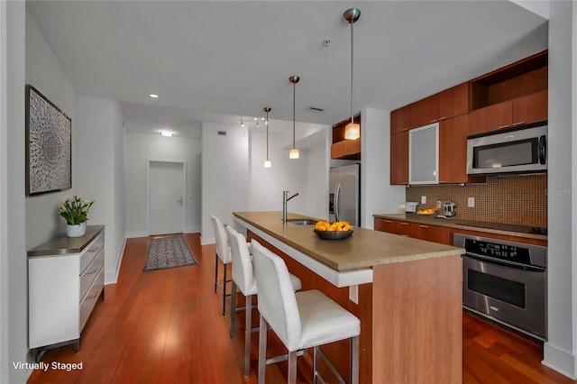 111 N 12th St Unit 1614, Tampa, FL 33602 - kitchen with stainless steel appliances, a sink, decorative backsplash, brown cabinets, and modern cabinets