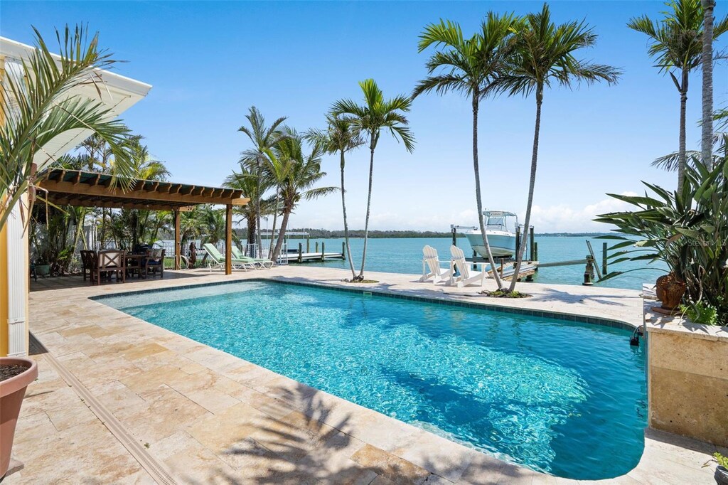 571 Johns Pass Ave, Madeira Beach, FL 33708 - pool with a patio, boat lift, a dock, a water view, and a pergola