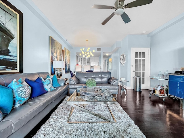 living area with wood finished floors, a chandelier, a ceiling fan, and baseboards