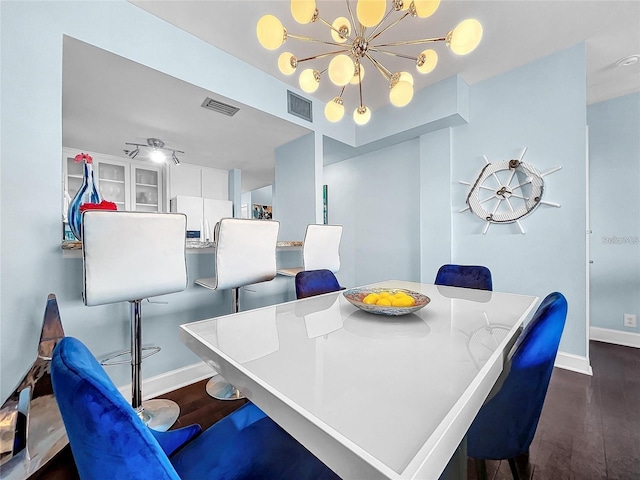 dining area with a chandelier, wood finished floors, and baseboards