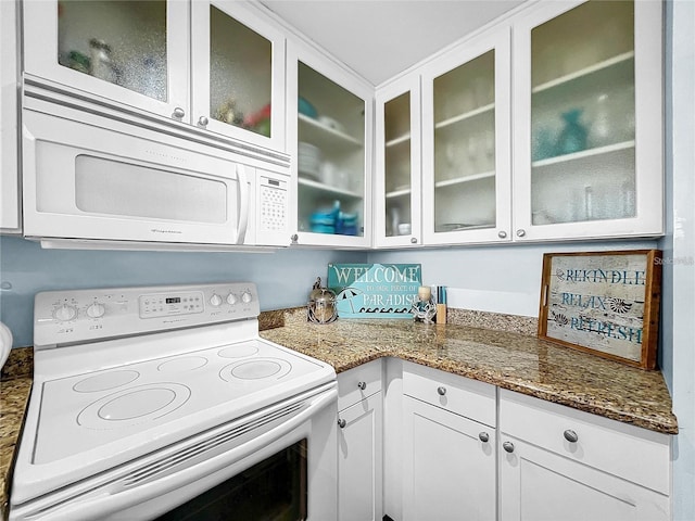 kitchen featuring white appliances, white cabinets, glass insert cabinets, and stone countertops