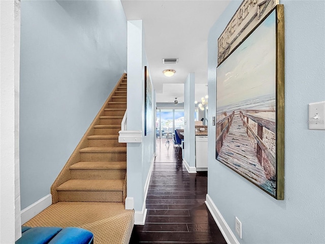 stairway with wood finished floors and baseboards