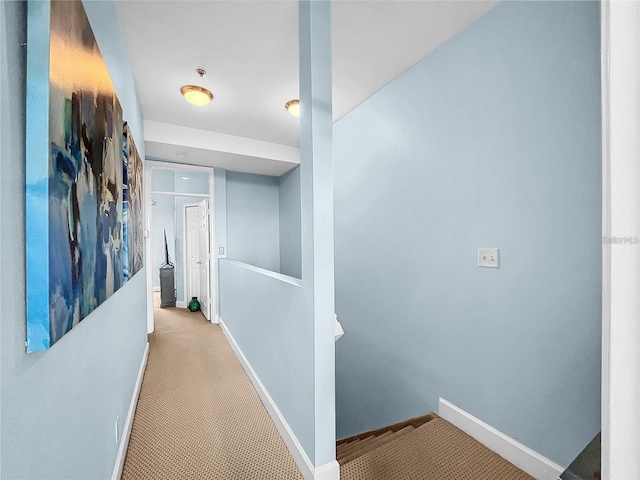 corridor with baseboards and carpet
