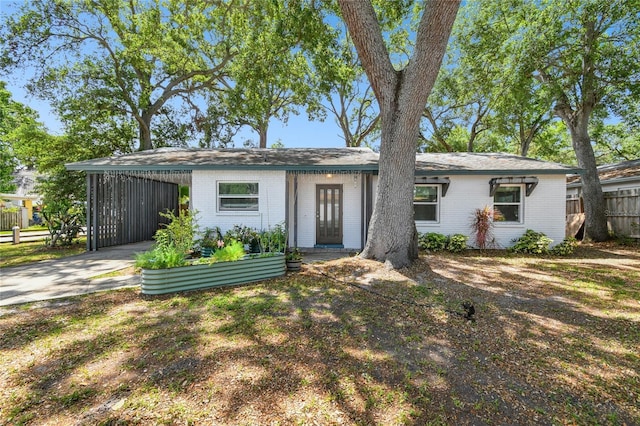 3202 W Coachman Ave, Tampa, FL 33611 - view of front of house with brick siding, driveway, and a carport