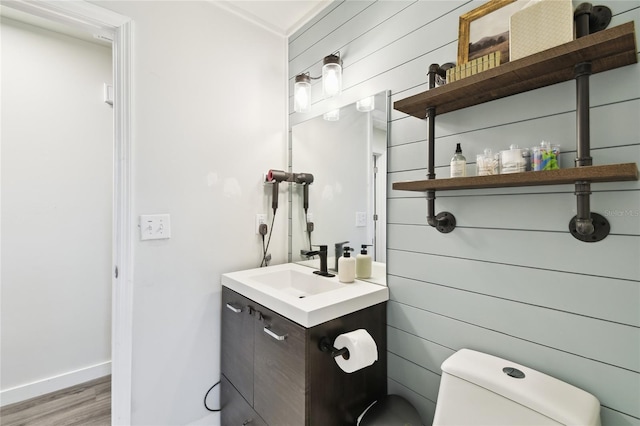 3202 W Coachman Ave, Tampa, FL 33611 - bathroom with toilet, vanity, wood finished floors, wood walls, and baseboards
