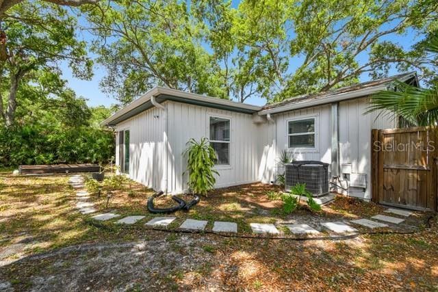 3202 W Coachman Ave, Tampa, FL 33611 - back of property featuring central air condition unit and board and batten siding