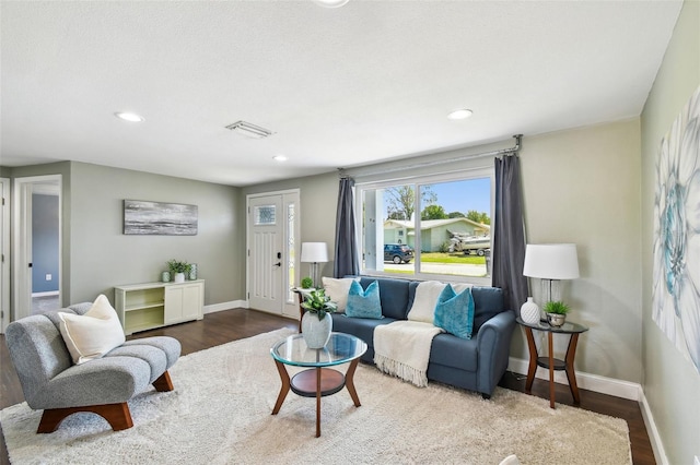 living area featuring baseboards, visible vents, recessed lighting, and wood finished floors