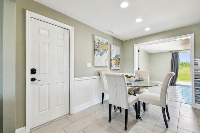 dining area with a wainscoted wall and recessed lighting