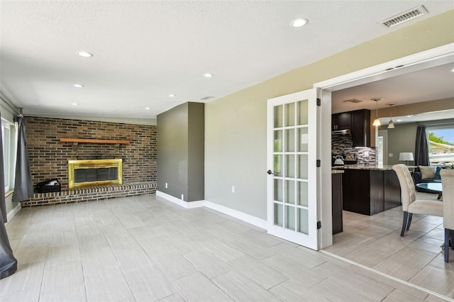 living room featuring baseboards, a fireplace, visible vents, and recessed lighting