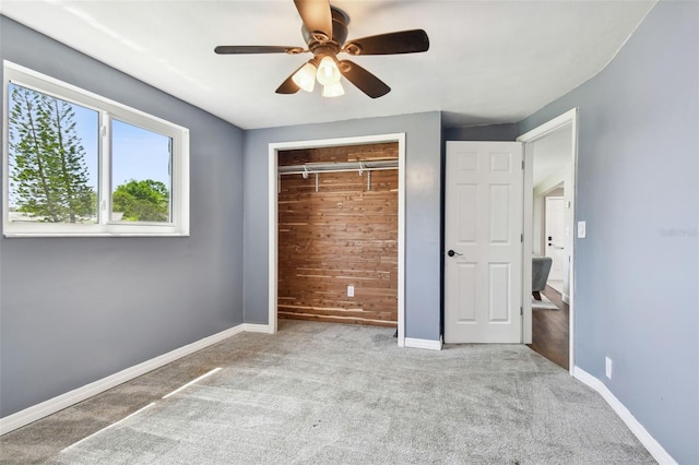 unfurnished bedroom featuring baseboards, a closet, carpet floors, and a ceiling fan