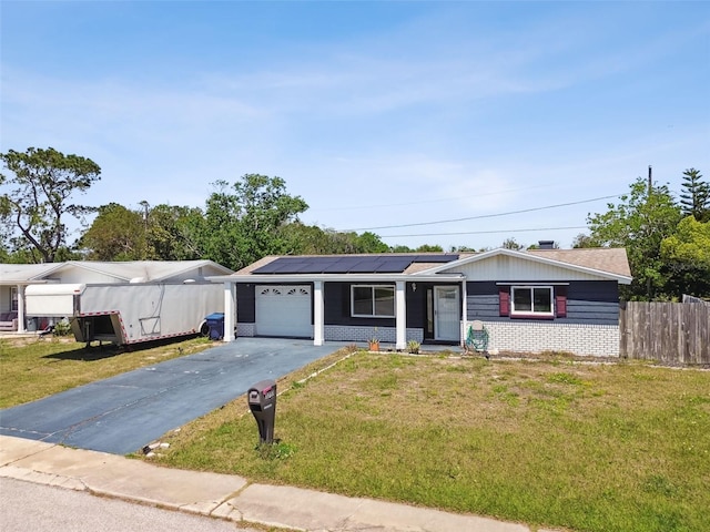single story home featuring brick siding, driveway, a garage, and a front lawn
