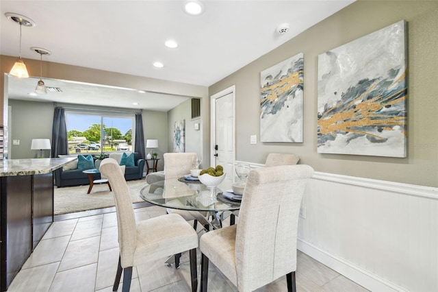 dining area with a wainscoted wall and recessed lighting