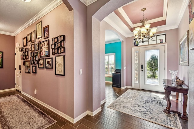 21627 Pearl Crescent Ct, Land O Lakes, FL 34637 - entrance foyer featuring a notable chandelier, baseboards, ornamental molding, dark wood-style floors, and arched walkways