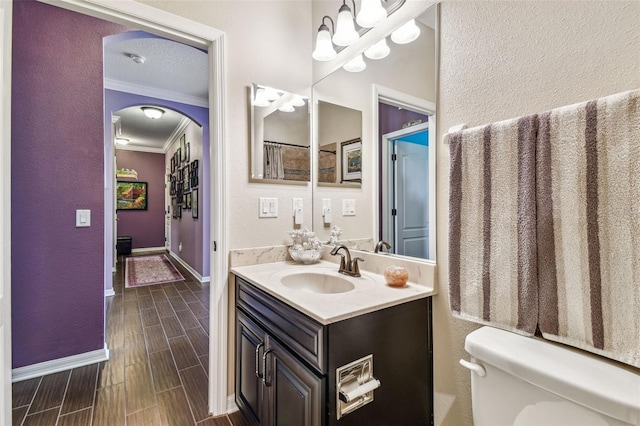 21627 Pearl Crescent Ct, Land O Lakes, FL 34637 - bathroom featuring vanity, baseboards, a textured wall, crown molding, and toilet